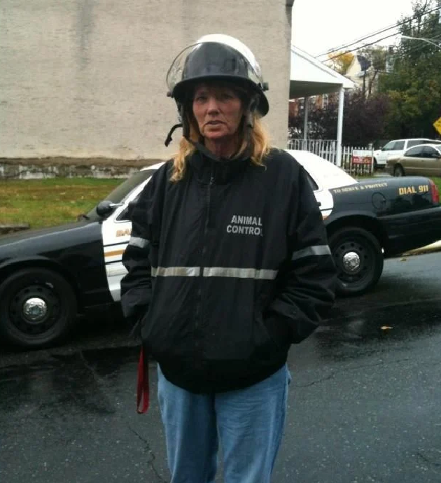 Animal control officer standing by police car.