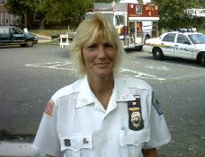Woman in uniform near emergency vehicles